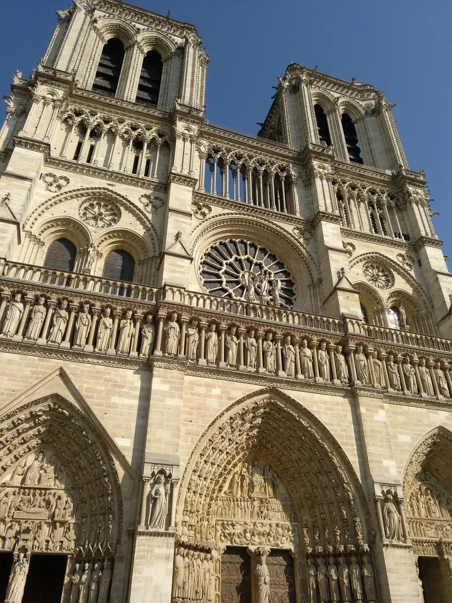 The west façade of Notre-Dame de Paris, showing its three carved portals, central rose window and twin towers stacked in horizontal bands
