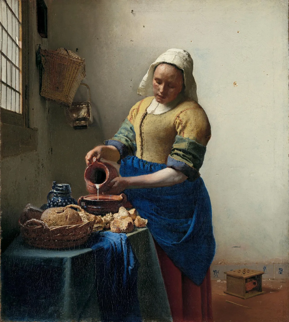Johannes Vermeer's The Milkmaid, c. 1660 — a figure pouring milk demonstrates emphasis through value contrast and proportion against a simple background